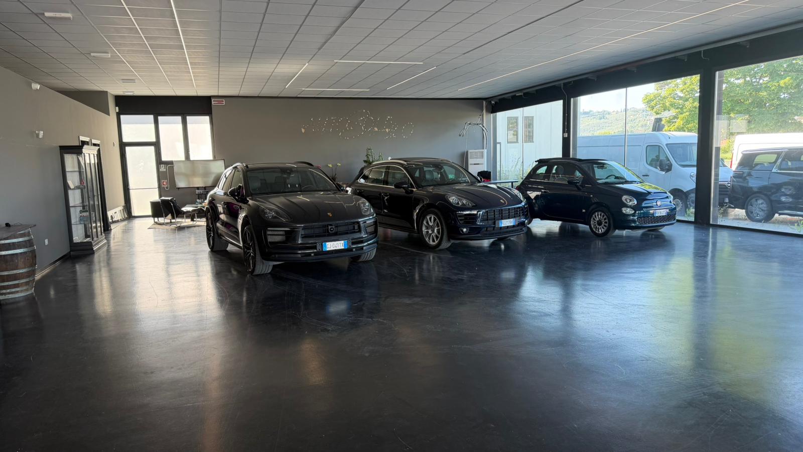 Showroom interno con Porsche e Fiat 500